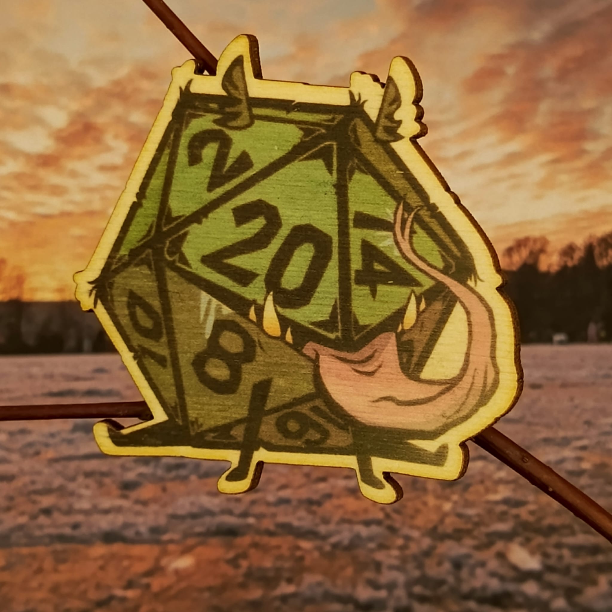 Brož s dvacetistěnným symbolem volby a náhody.