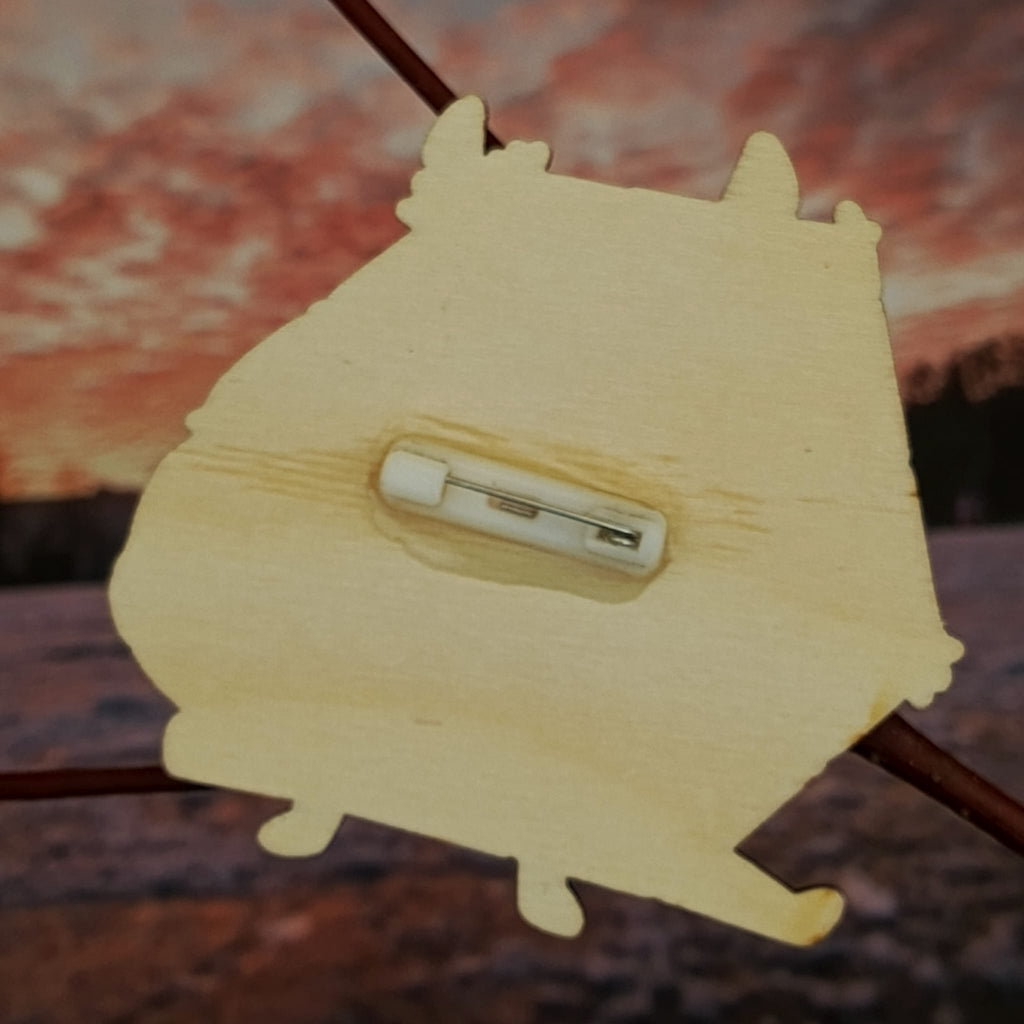 Brož s dvacetistěnným symbolem volby a náhody.